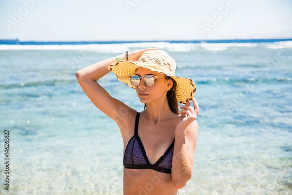 Obraz woman in hat and sunglasses on the beach with sea background