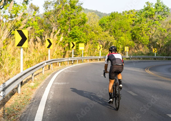 Fototapeta Asian men are cycling road bike morning uphill on the road