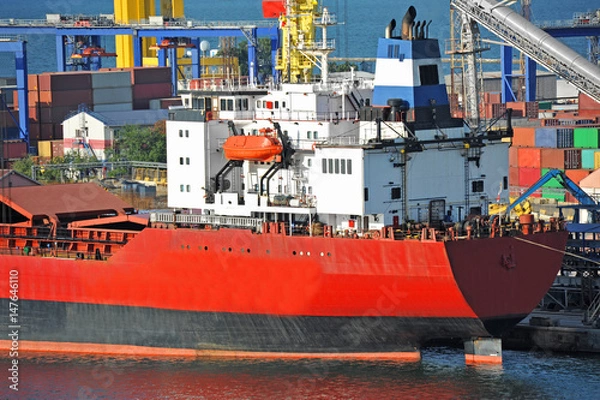 Fototapeta Bulk cargo ship under port crane