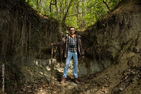 Fototapeta Photographer hiking in the forest and posing for a camera