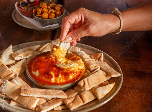 Fototapeta Hummus and Pita Bread with Human Hand