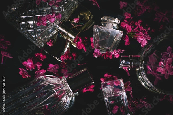 Fototapeta different female bottles of perfume with lilac flowers