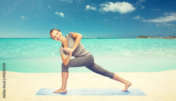 Fototapeta woman making yoga low angle lunge pose on mat