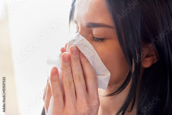 Fototapeta close up of woman with wipe blowing nose or crying