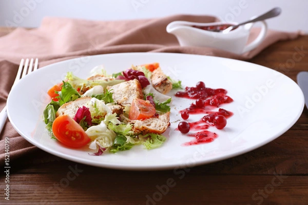 Fototapeta Portion of salad and cranberry sauce on plate