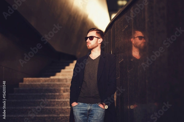 Fototapeta Stylish man in a coat and sunglasses. Copy space