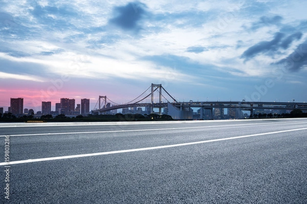 Fototapeta empty road with suspension bridge in modern city