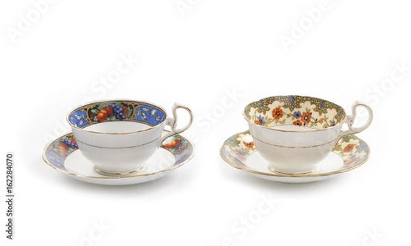 Fototapeta Two beautiful vintage tea cups with saucers isolated on a white background.