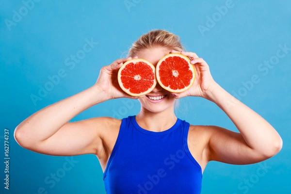 Fototapeta Woman holding grapefruit citrus fruit in hands