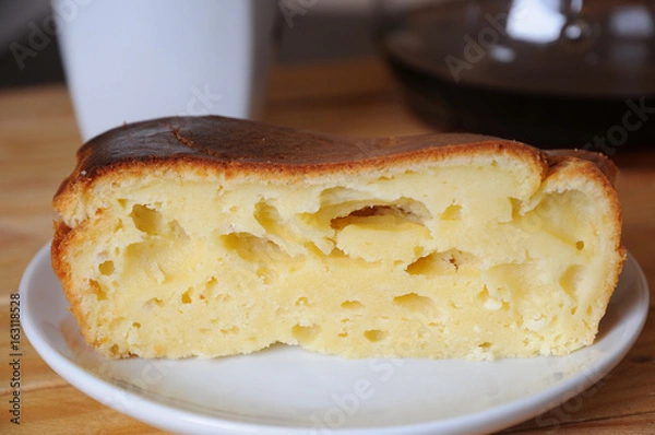 Fototapeta A piece of curd cake close-up. Coffee in the background