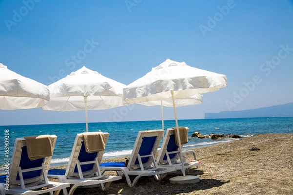 Fototapeta beach chairs and umbrellas on sand beach