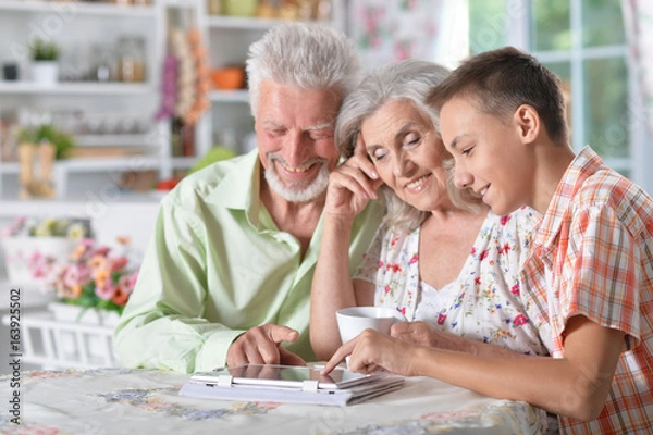 Fototapeta boy with  grandparents using  tablet