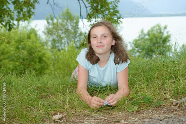 Fototapeta Beautiful pre teenage girl laying in grass