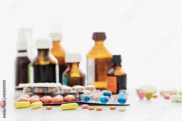 Fototapeta Composition of medicine bottles and pills  on white background