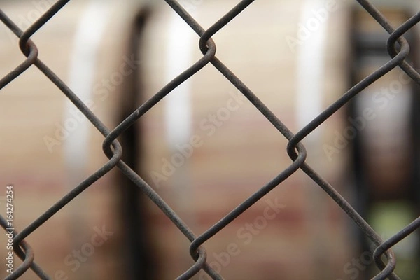 Fototapeta Wire mesh braided metal grid view through.