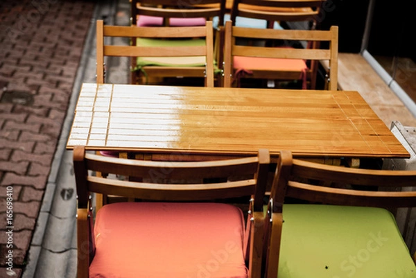 Fototapeta ISTANBUL, TURKEY - May 6, 2017: Interior Retro, vintage view of Pastel coffee shop with wooden tables and chairs in Balat, old town of Istanbul, Turkey. Outdoor cafe. Photo in vintage image style.