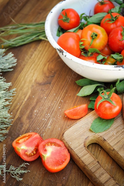 Fototapeta Ripe tomatoes on an old wooden table in rustic style