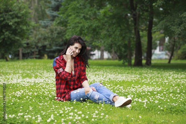 Fototapeta Portrait of beautiful caucasian smiling brunette young woman calling by phone