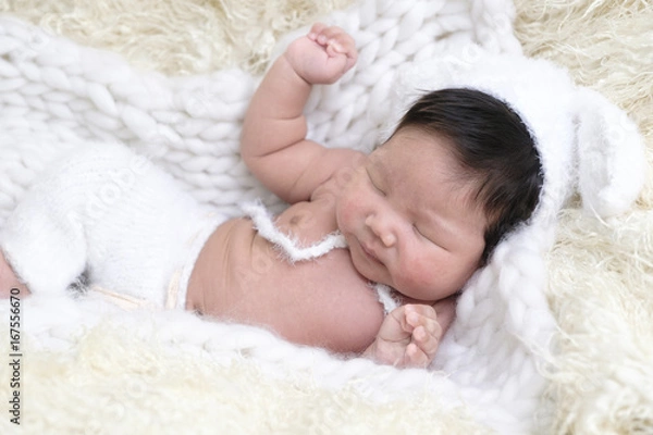 Fototapeta Portrait of Asia boy newborn is lay down on white fur background with bear .