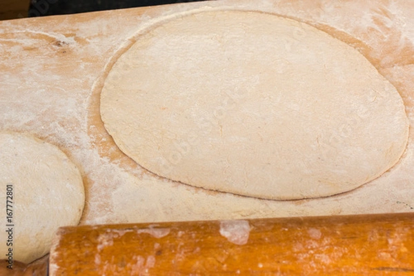 Obraz Rolled out pizza dough on floured surface.