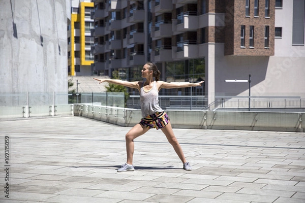 Fototapeta Attractive woman exercise stretching in urban environment at sunny day