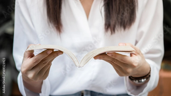 Fototapeta Close up of woman hand holding book