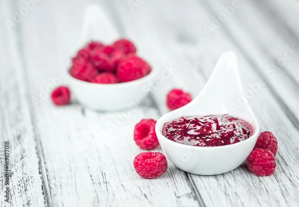 Fototapeta Raspberry Jam on wooden background; selective focus