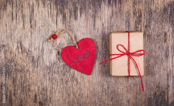 Fototapeta Red wooden heart and gift box on an old wooden background. Romantic concept. St. Valentine's Day