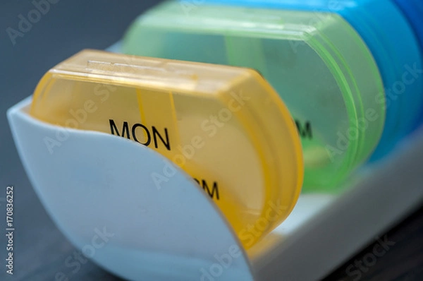 Fototapeta Daily pill boxes. Close-up of medicine dose box. Prescription pills in a pill box.