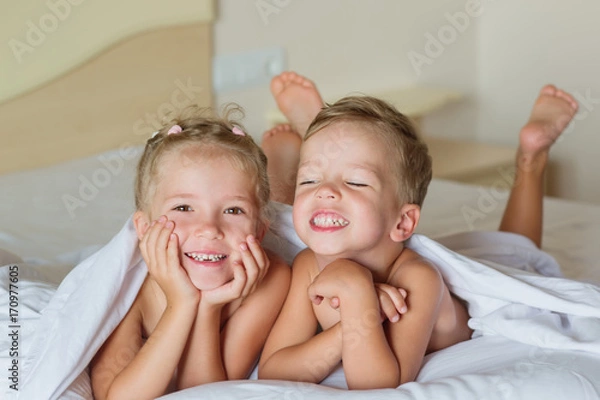 Fototapeta The charming children playing on the bed