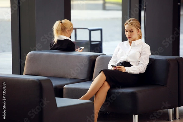 Fototapeta Businesswoman with phone in lobby