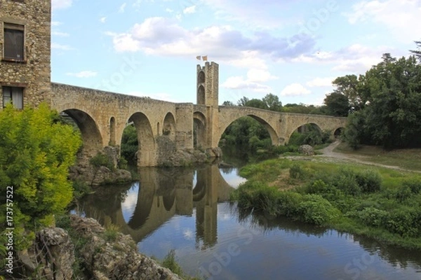 Fototapeta bridge and a tower over a river and its reflection, Spain