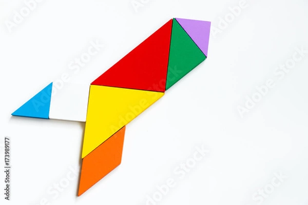 Fototapeta Colorful wood tangram puzzle in rocket or missile shape on white background