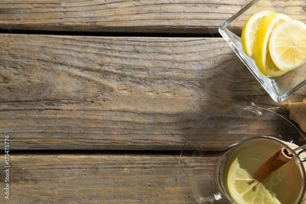 Fototapeta Overhead view of ginger tea with lemons on table