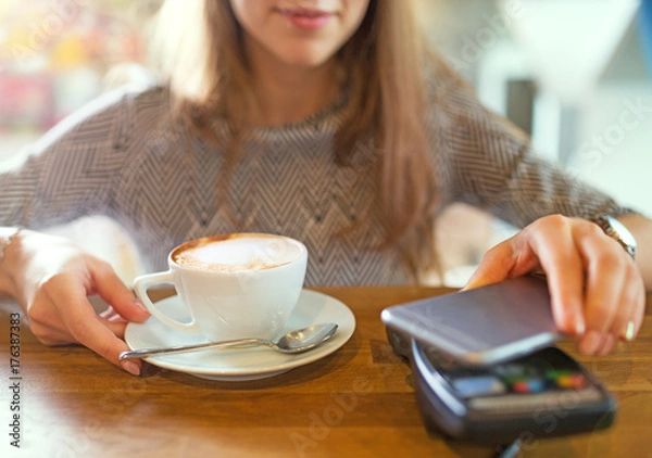 Fototapeta Customer Paying Through Mobile Phone In Cafe
