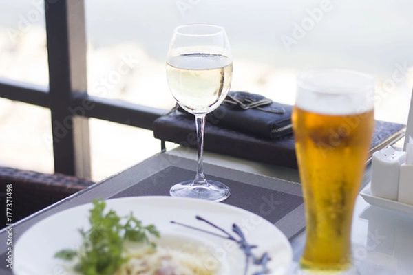 Fototapeta mug of beer with a nice salad with cheese and ham are on the table in a cafe