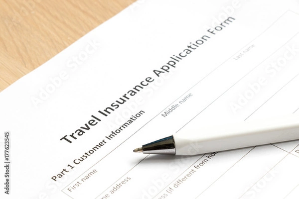 Fototapeta Travel insurance application form wait to fill information on desk background