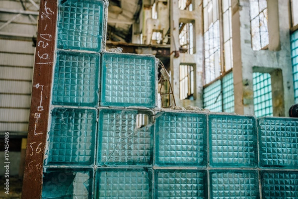 Fototapeta Fragment of broken wall from glass blocks in abandoned industrial building