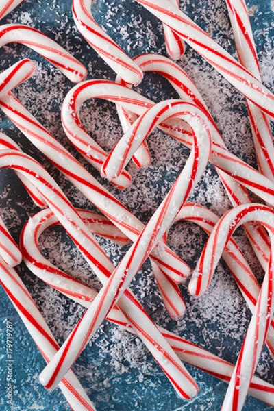 Fototapeta Candy cane on a blue background. Winter new year background.