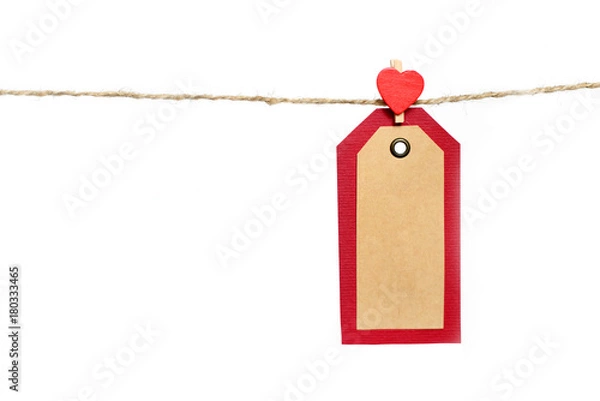 Fototapeta Two red and brown paper tags hanging on the rope by heart shape pin with copy space isolated on white background. St. Valentines gift concept.