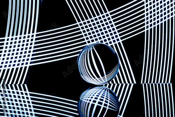 Fototapeta Glass ball with white light streaks reflecting and refracting light