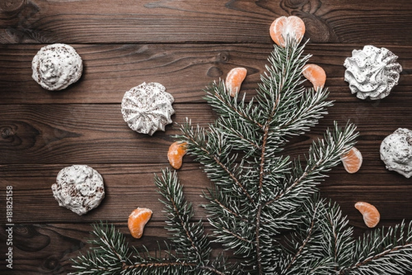 Fototapeta Brown wood background. Slice of mandarins. Sweets. Fir tree and cones. Christmas greeting card and new year. Xmas and Happy New Year composition. Flat lay, top view