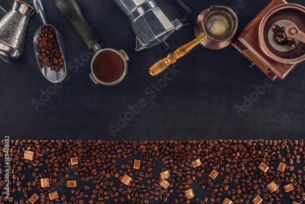 Fototapeta top view of roasted coffee beans with brown sugar and various coffee makers and grinders on black