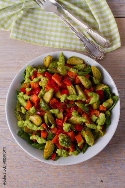 Fototapeta Roasted vegetable salad with avocado dressing. View from above, top, vertical