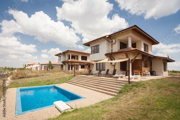 Fototapeta Swimming pool outside luxury home. Suburban houses. Perfect neighborhood