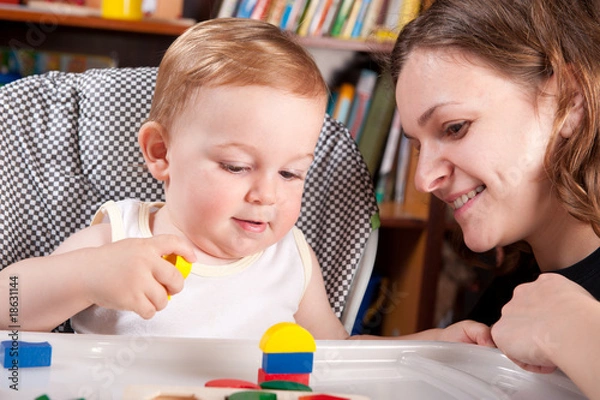 Fototapeta Mother playing with her son in blocks