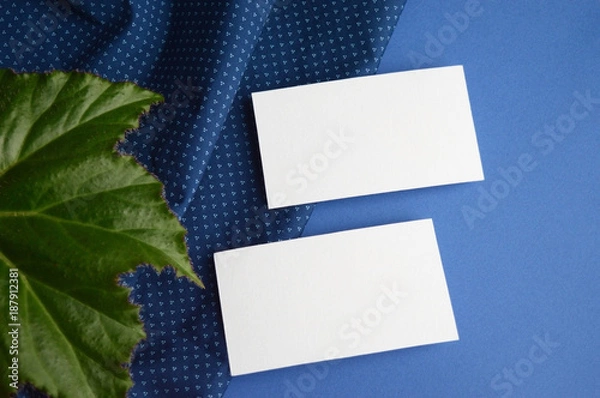 Fototapeta Mockup for a two-sided business card on a cloth and a begonia leaf