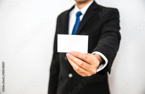 Fototapeta Business man hold white name card paper on hand with isolated white background