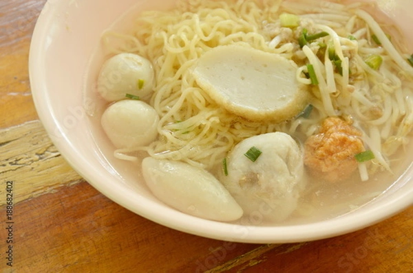 Fototapeta Chinese egg noodles topping fish dumpling and shrimp ball in clear soup on bowl