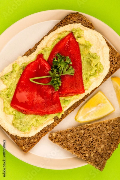 Fototapeta Red Peppers With Avocado and Hummus On Rye Open Face Sandwich